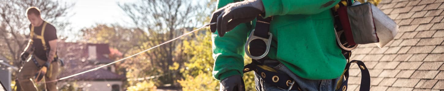 Photo d'un artisan couvreur qui effectue des mesures sur une toiture